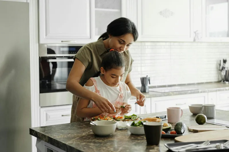 Mother and daughter preparing nutrient-rich meals to address vitamin deficiencies through a balanced diet.