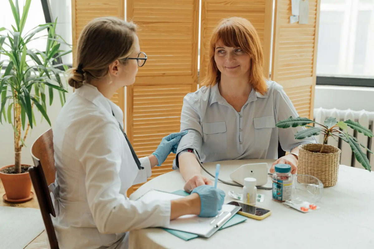 Doctor checking patient's blood pressure, demonstrating how to prevent high blood pressure through regular monitoring