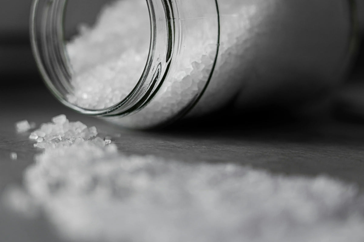 Salt granules spilled from a jar, representing genes that affect salt sensitivity and health.
