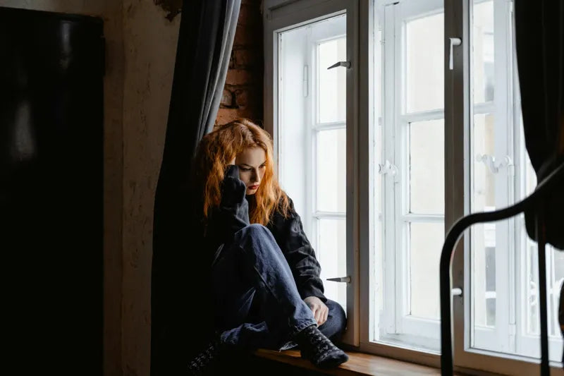 A woman reflecting on how to prevent PCOS through understanding symptoms and genetic factors.
