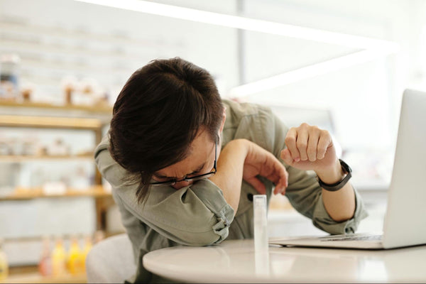 Person holding stomach while looking at a menu—confusion between allergy, intolerance, and sensitivity