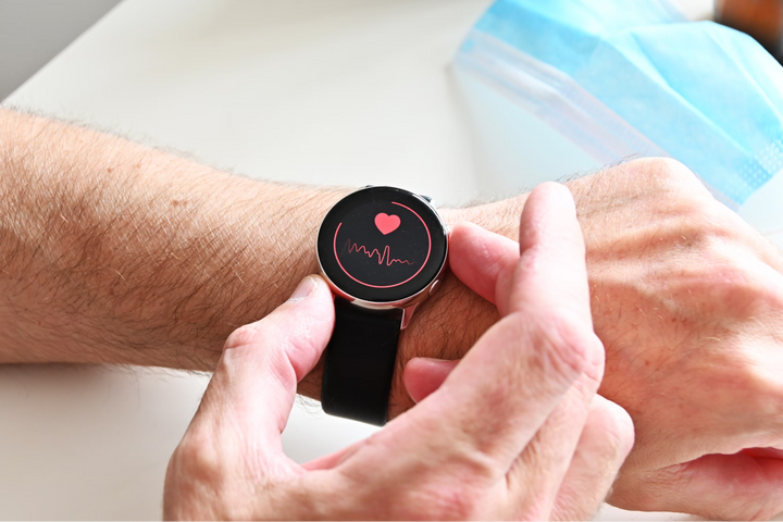  Person checking heart rate on smartwatch, symbolizing genetic predisposition to heart disease